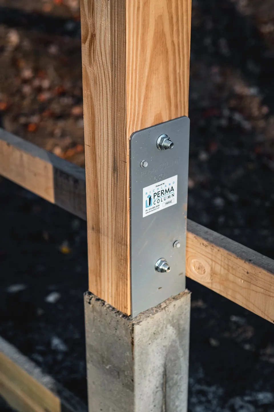 Close-up of a Perma-Column bracket connecting a timber post to its concrete base