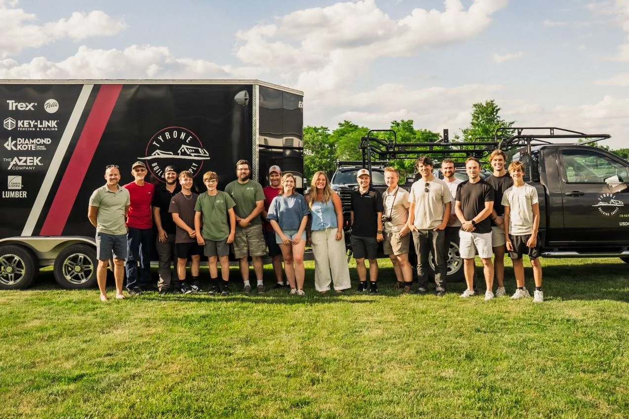 The Tyrone Building Supply team standing beside a branded trailer and pickup truck